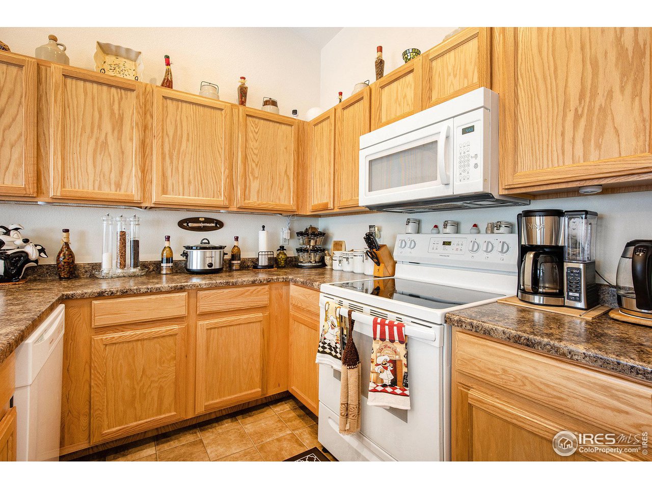 1329 85th Avenue Greeley, CO 80634 - Photo 10 of 22 a kitchen with stainless steel appliances granite countertop a stove a sink and a refrigerator