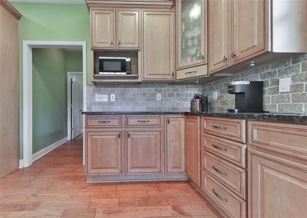 1523 Braswell Mountain Road Dallas, GA 30132 - Photo 11 of 34 a kitchen with granite countertop white cabinets and stainless steel appliances