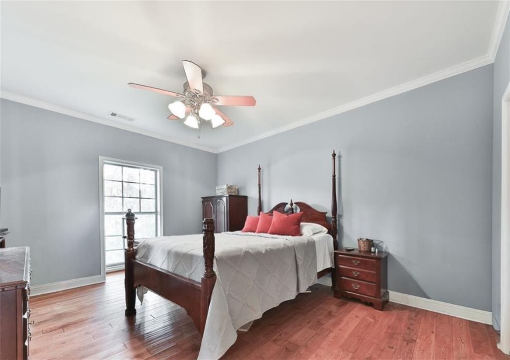 1523 Braswell Mountain Road Dallas, GA 30132 - Photo 14 of 34 a bedroom with a bed and a chandelier