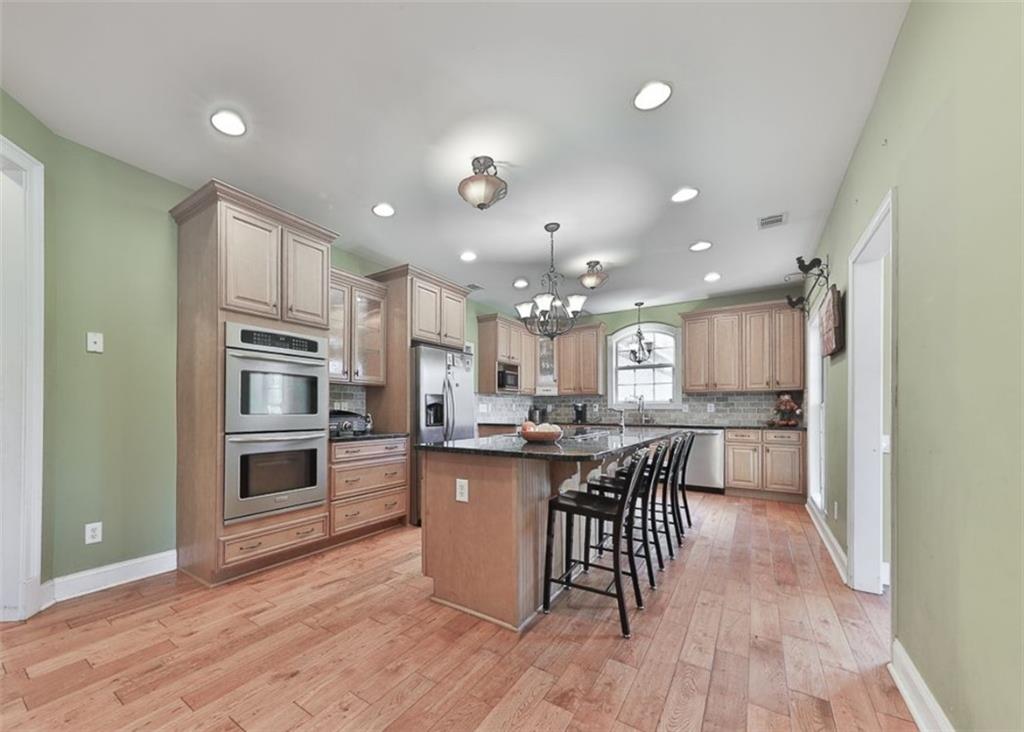 1523 Braswell Mountain Road Dallas, GA 30132 - Photo 7 of 34 a kitchen with kitchen island a large counter top space appliances and cabinets