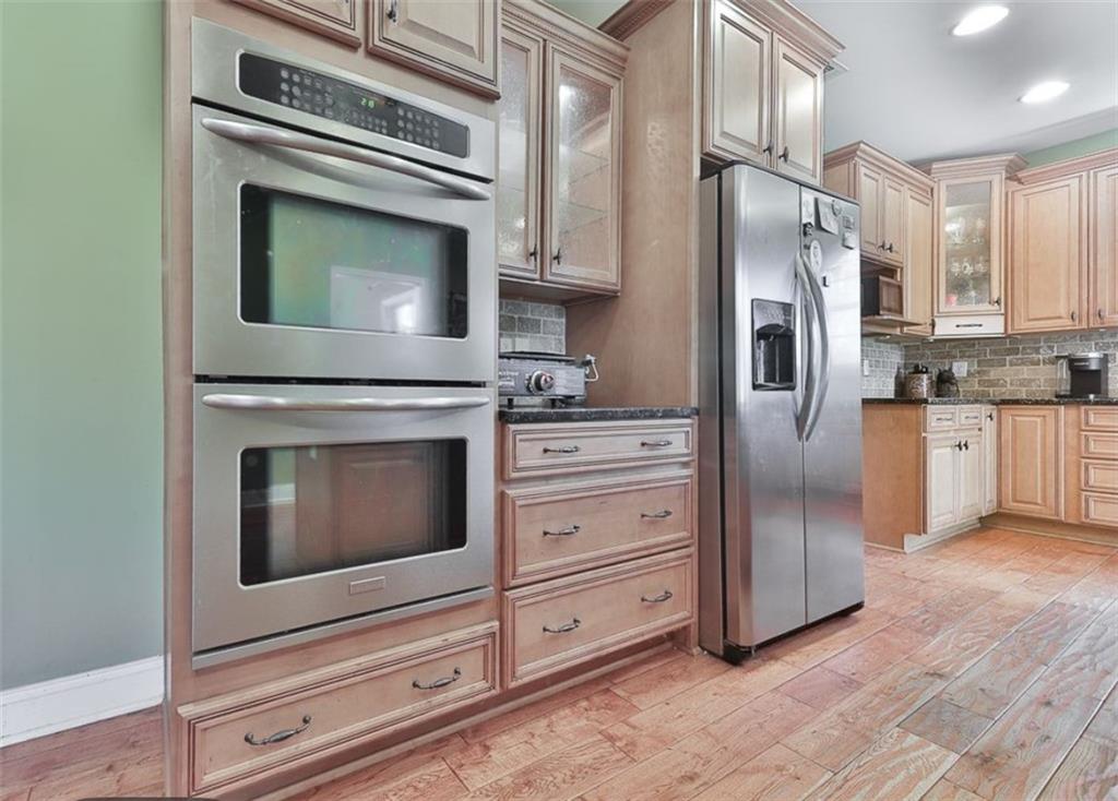 1523 Braswell Mountain Road Dallas, GA 30132 - Photo 8 of 34 a kitchen with granite countertop cabinets stainless steel appliances and wooden floor