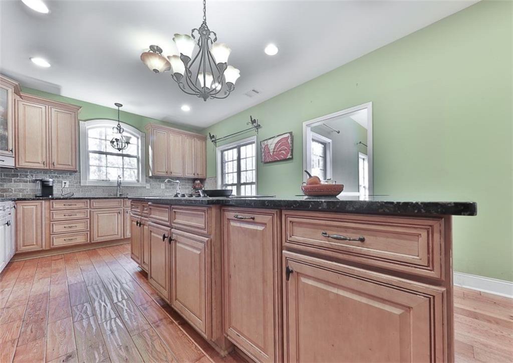 1523 Braswell Mountain Road Dallas, GA 30132 - Photo 9 of 34 a kitchen with stainless steel appliances granite countertop wooden cabinets a stove a sink and dishwasher next to a window