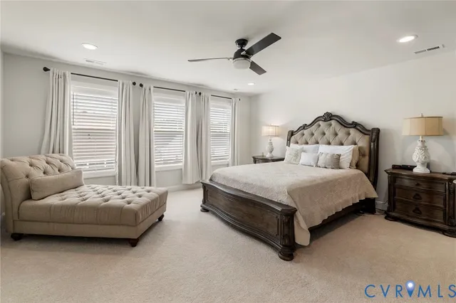 a bedroom with a large bed and ceiling fan