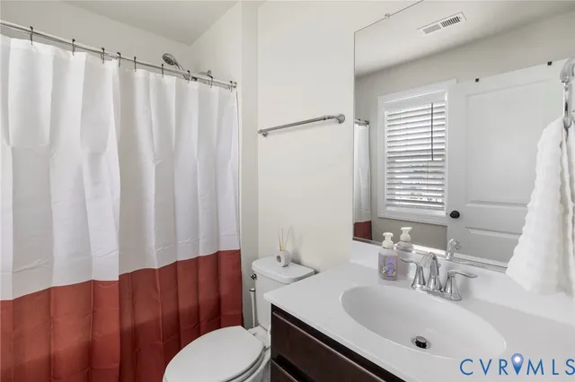 a living room with furniture a flat screen tv and a window