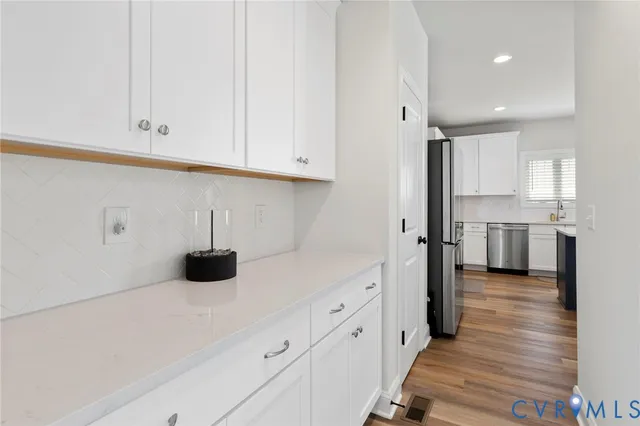 a kitchen with kitchen island granite countertop a sink cabinets and wooden floor