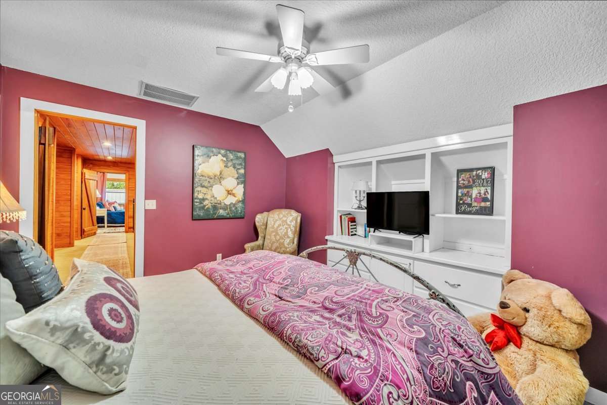 568 Hopewell Church Road Rhine, GA 31077 - Photo 32 of 79 a bedroom with a bed and a flat screen tv