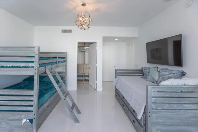 a bedroom with a bed and a flat tv screen on the dresser