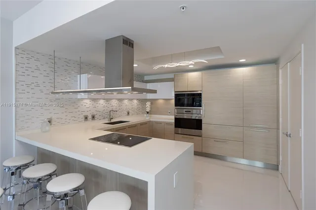 a kitchen with a sink a stove and chairs in it
