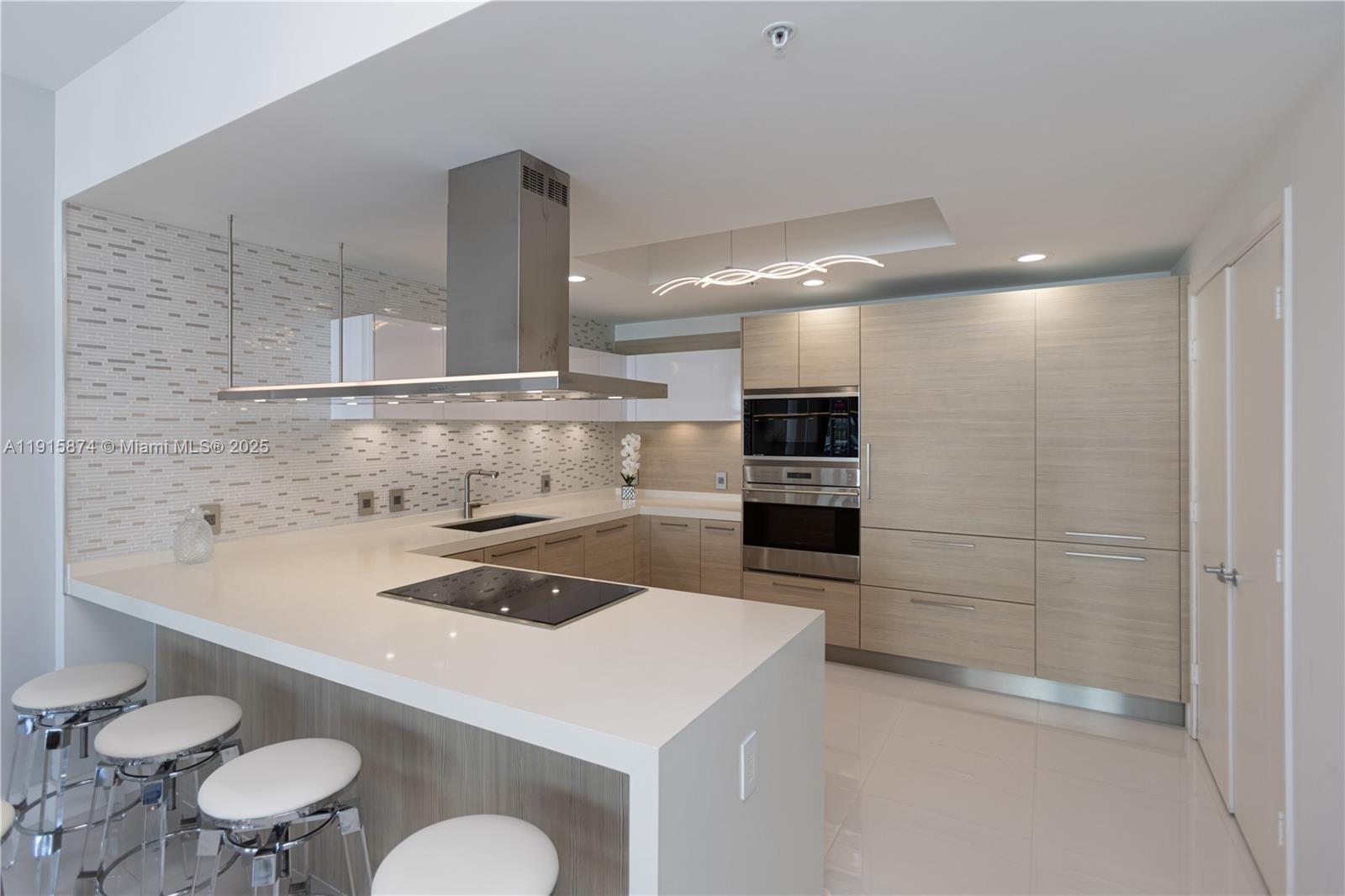 17111 Biscayne Boulevard, Unit 505 North Miami Beach, FL 33160 - Photo 15 of 29 a kitchen with a sink a stove and chairs in it