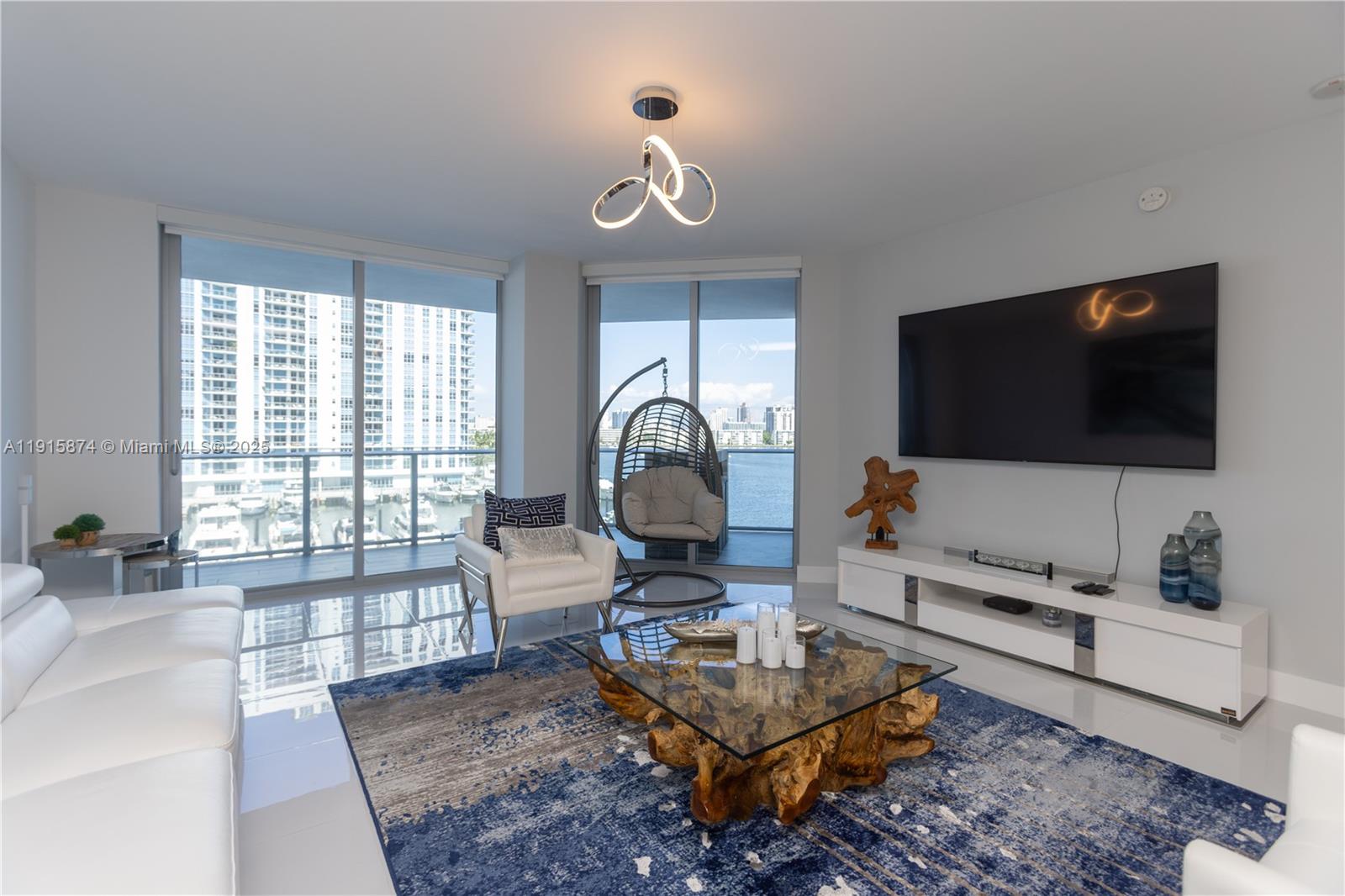 17111 Biscayne Boulevard, Unit 505 North Miami Beach, FL 33160 - Photo 23 of 29 a living room with furniture a flat screen tv and a floor to ceiling window