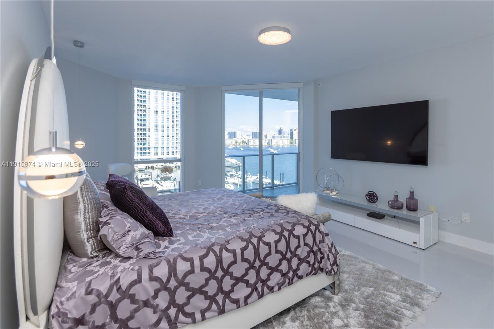17111 Biscayne Boulevard, Unit 505 North Miami Beach, FL 33160 - Photo 4 of 29 a bedroom with a bed and a flat screen tv
