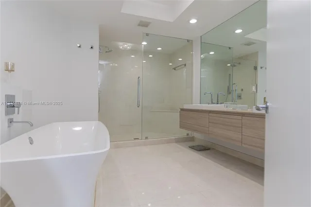 a bathroom with a bathtub a shower a sink and mirror
