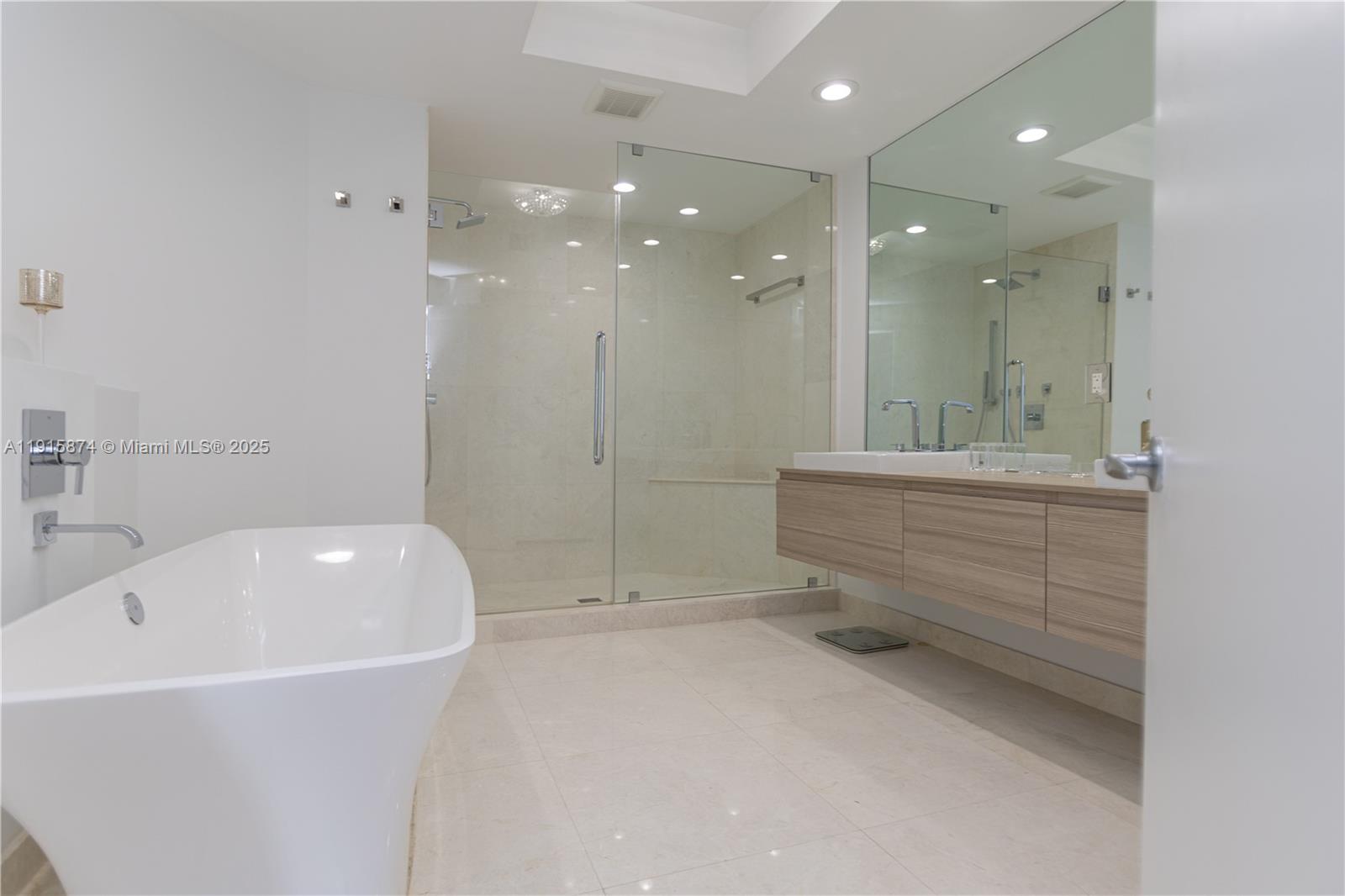 17111 Biscayne Boulevard, Unit 505 North Miami Beach, FL 33160 - Photo 8 of 29 a bathroom with a bathtub a shower a sink and mirror