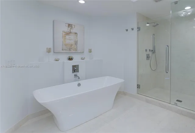 a white bath tub sitting next to a shower