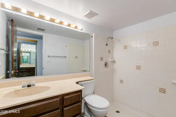a bathroom with a sink a toilet a mirror and shower