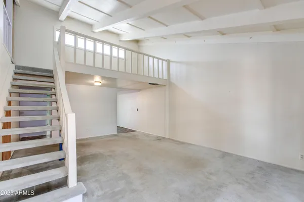 a view of an empty room with a fireplace and a window