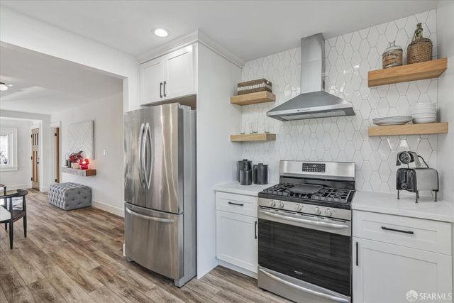 a kitchen with stainless steel appliances a stove a refrigerator and a cabinets