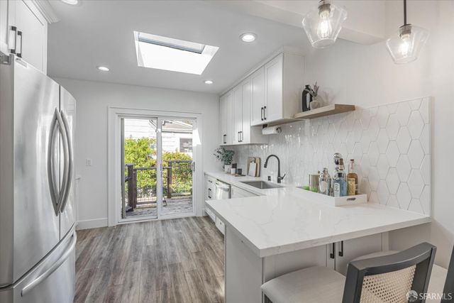a kitchen with kitchen island a stove a sink and wooden floor