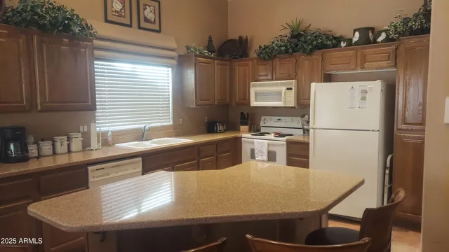 a kitchen with stainless steel appliances granite countertop a sink a refrigerator and a stove