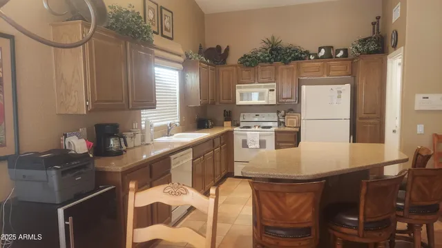 a kitchen with stainless steel appliances granite countertop a sink a stove a refrigerator cabinets and dining table