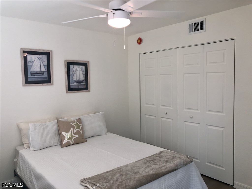 16881 Davis Road, Unit 214 Fort Myers, FL 33908 - Photo 16 of 46 a bedroom with a large bed and a chandelier