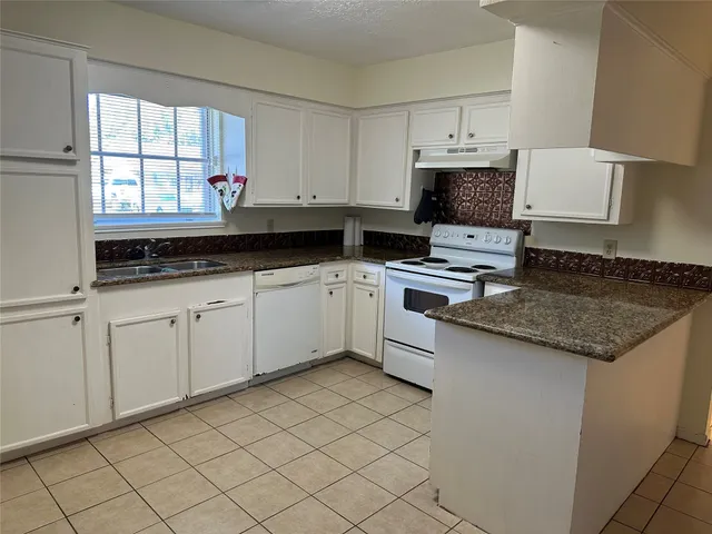 a kitchen with stainless steel appliances granite countertop a sink and a stove