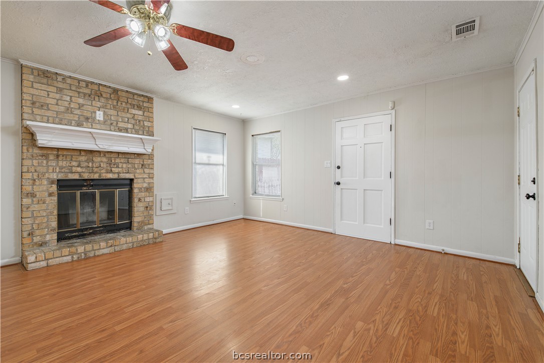 4403 Robinhood Circle Bryan, TX 77803 - Photo 4 of 19 a view of an empty room with wooden floor fireplace and a window