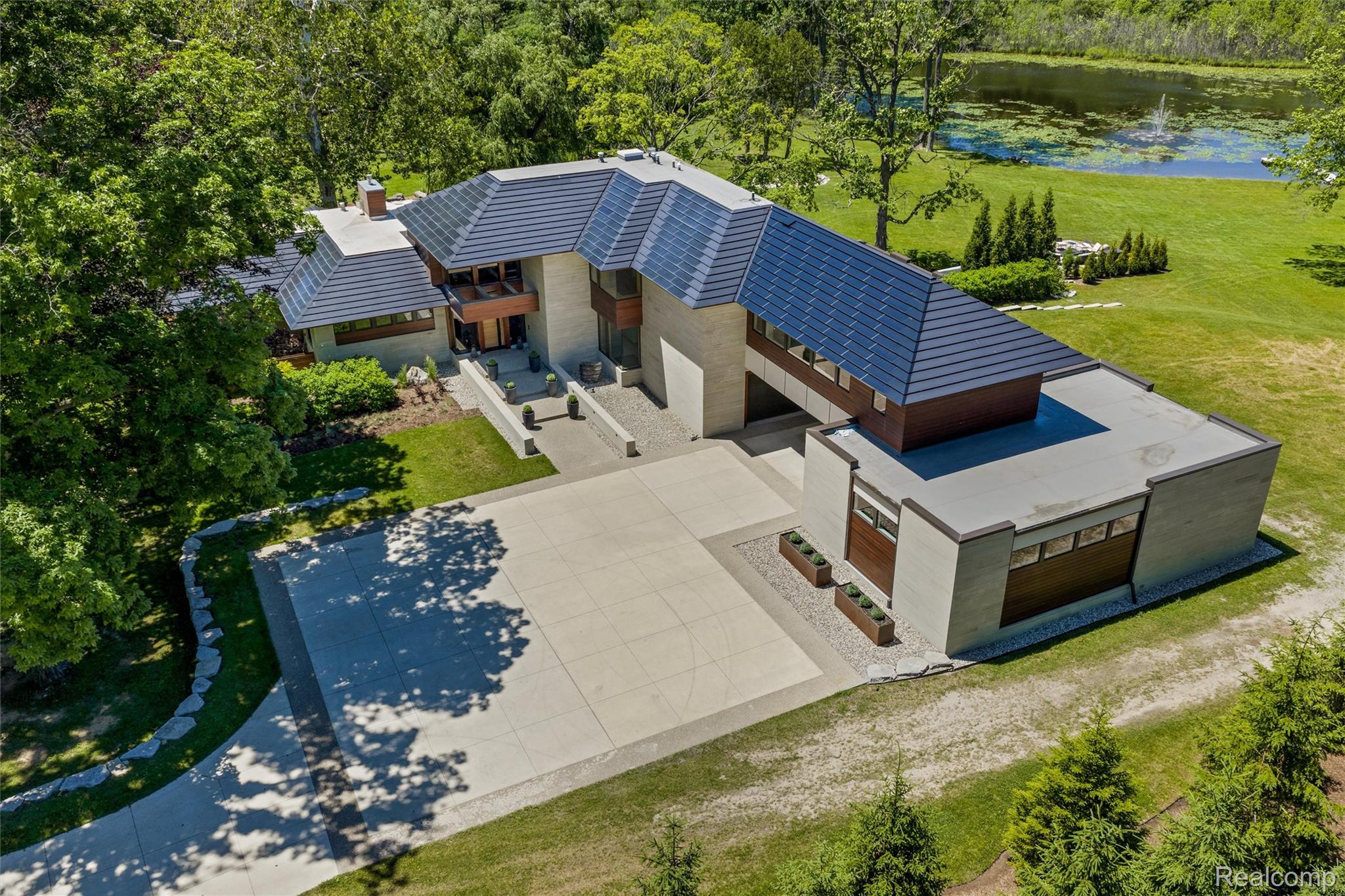2700 Squirrel Road Bloomfield Hills, MI 48304 - Photo 78 of 83 Contemporary residence featuring a multi-level roofline, extensive concrete driveway, and a pond with a fountain