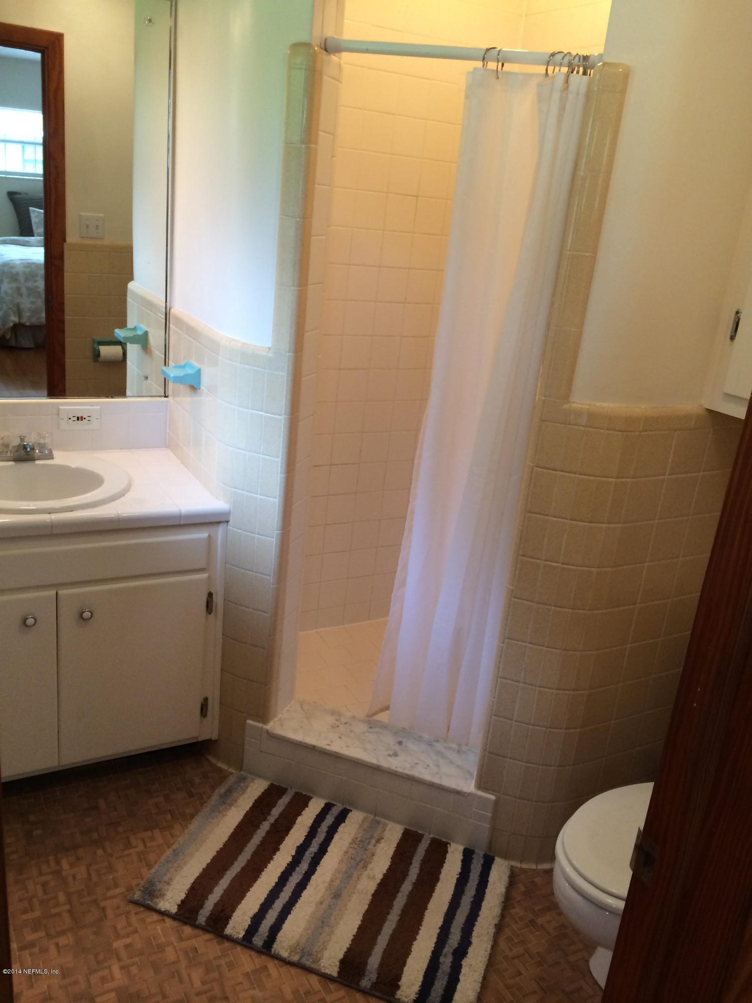 5114 Damascus Road South Jacksonville, FL 32207 - Photo 10 of 12 a bathroom with a sink a toilet a window and vanity