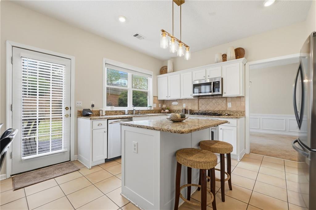 2135 Sugar Maple Lane Northwest Acworth, GA 30101 - Photo 16 of 59 a kitchen with kitchen island white cabinets and white appliances