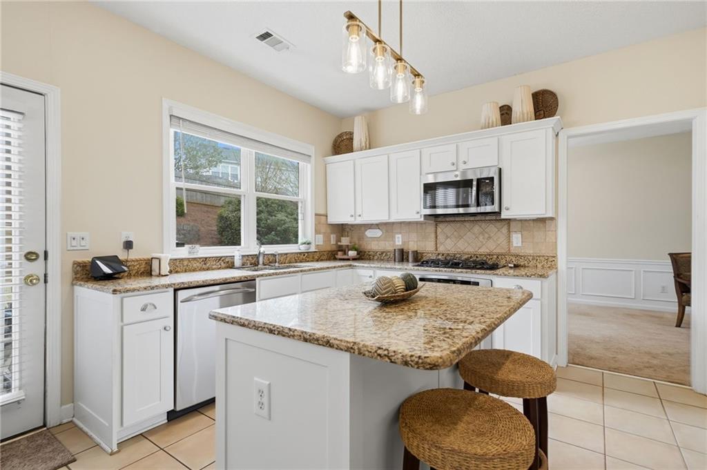 2135 Sugar Maple Lane Northwest Acworth, GA 30101 - Photo 17 of 59 a kitchen with granite countertop a sink a counter top space appliances and cabinets