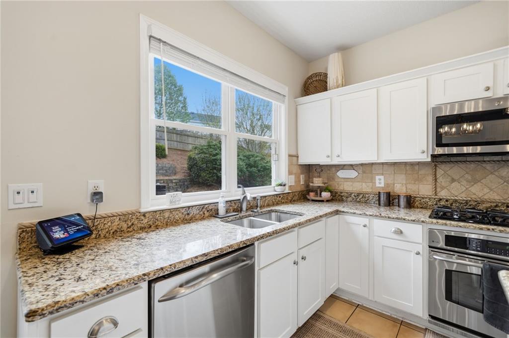 2135 Sugar Maple Lane Northwest Acworth, GA 30101 - Photo 19 of 59 a kitchen with stainless steel appliances granite countertop a sink stove and cabinets