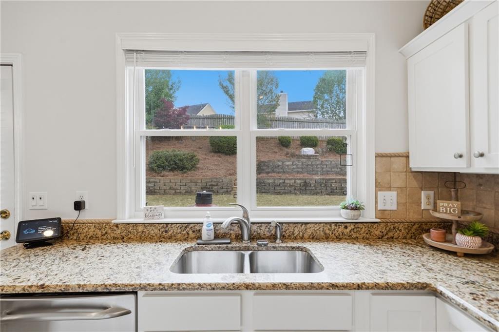 2135 Sugar Maple Lane Northwest Acworth, GA 30101 - Photo 20 of 59 a kitchen with granite countertop a sink window and cabinets