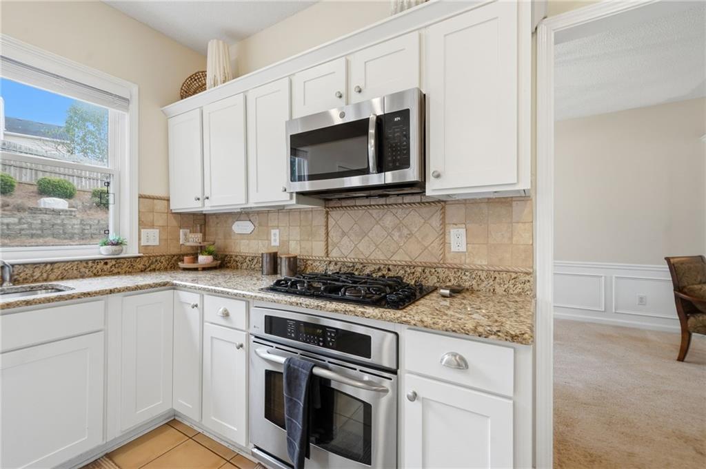 2135 Sugar Maple Lane Northwest Acworth, GA 30101 - Photo 21 of 59 a kitchen with stainless steel appliances granite countertop white cabinets a microwave oven and a sink