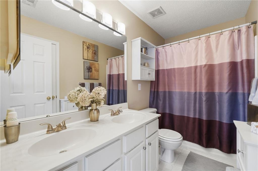 2135 Sugar Maple Lane Northwest Acworth, GA 30101 - Photo 27 of 59 a bathroom with a sink a toilet and shower curtain