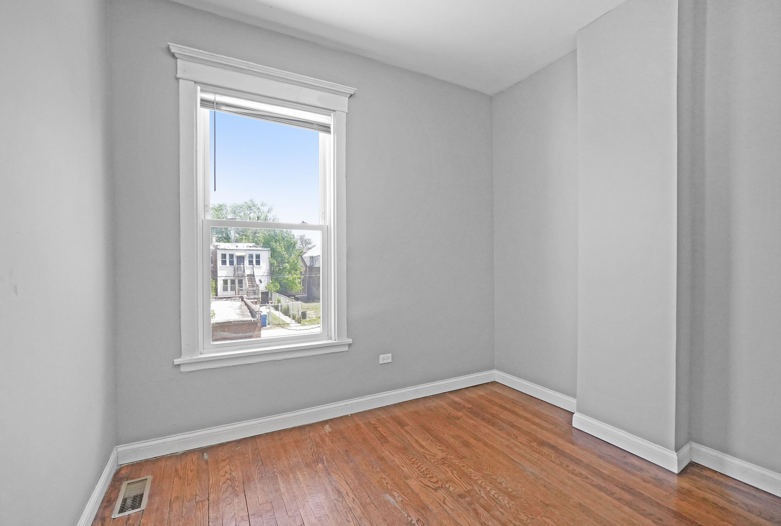 6409 South Champlain Avenue Chicago, IL 60637 - Photo 11 of 33 a view of an empty room with wooden floor and a window