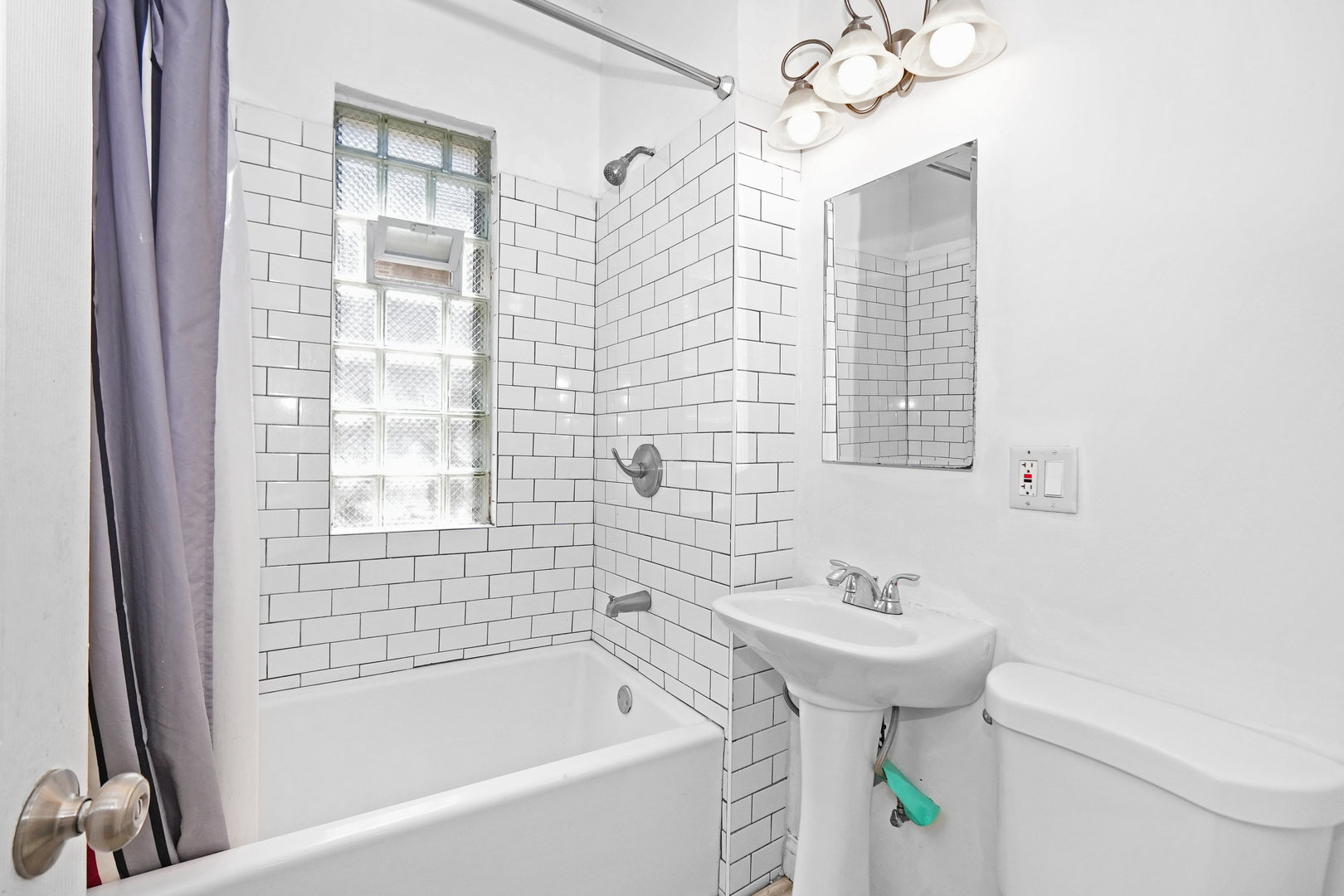 6409 South Champlain Avenue Chicago, IL 60637 - Photo 12 of 33 a bathroom with a sink a toilet and shower