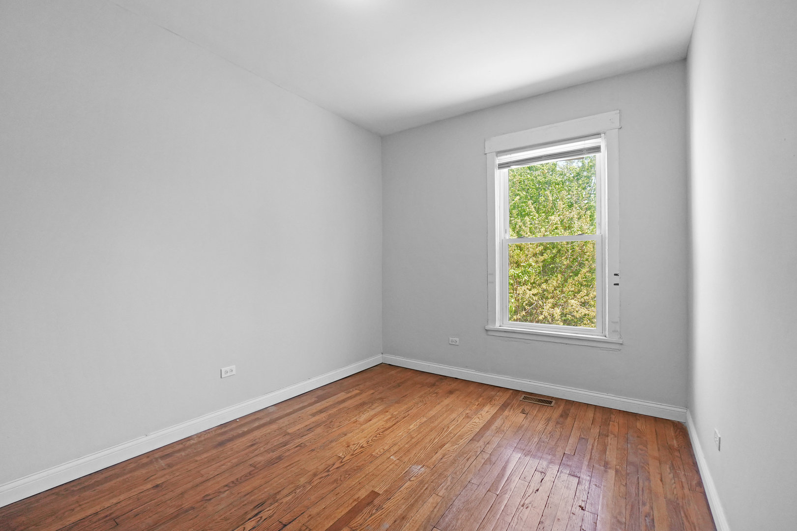 6409 South Champlain Avenue Chicago, IL 60637 - Photo 16 of 33 an empty room with wooden floor and windows