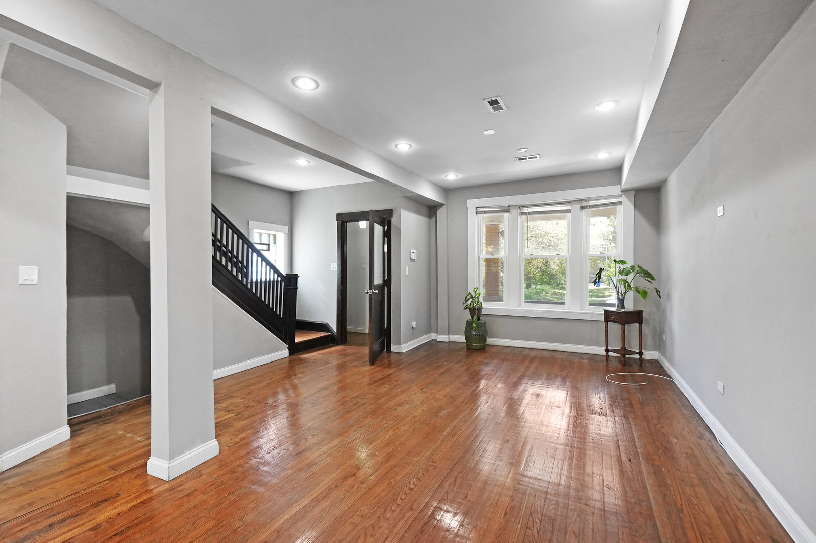 6409 South Champlain Avenue Chicago, IL 60637 - Photo 5 of 33 a view of an empty room with wooden floor and a window