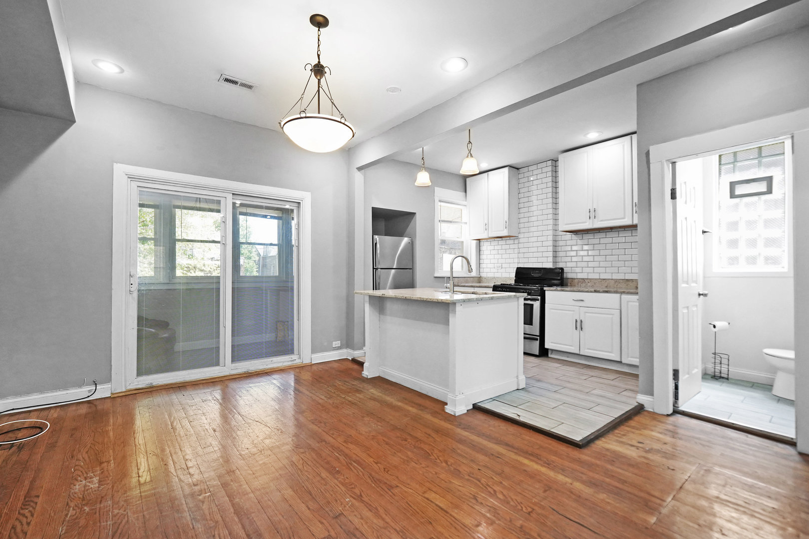 6409 South Champlain Avenue Chicago, IL 60637 - Photo 6 of 33 a open kitchen with white cabinets and wooden floor