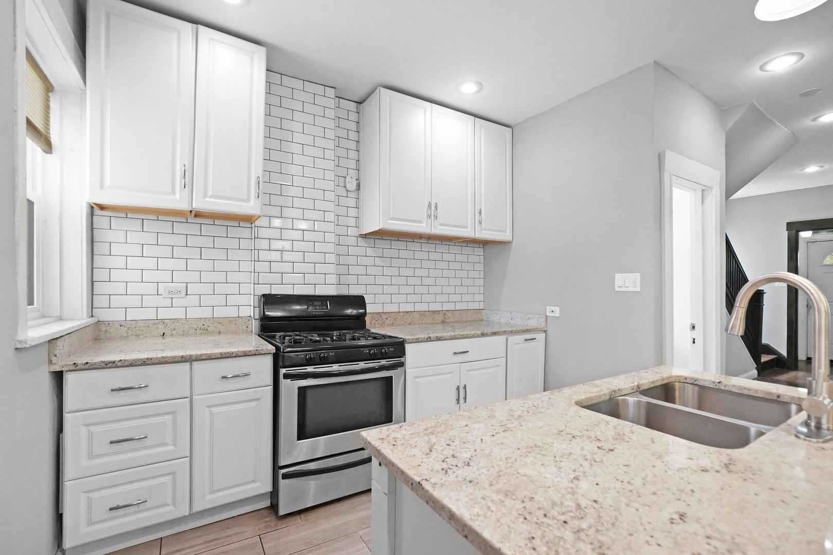6409 South Champlain Avenue Chicago, IL 60637 - Photo 9 of 33 a kitchen with granite countertop white cabinets sink and stainless steel appliances