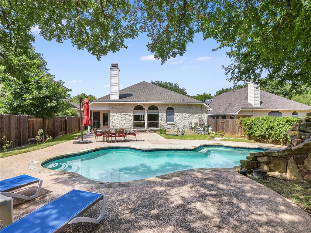 a front view of a house with swimming pool having outdoor seating