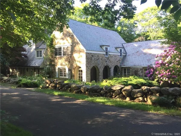 a front view of a house with a yard and outdoor seating