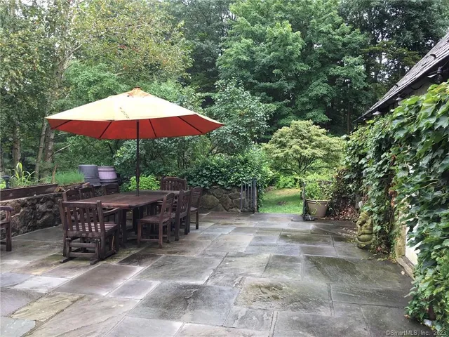 a view of backyard with outdoor seating and trees