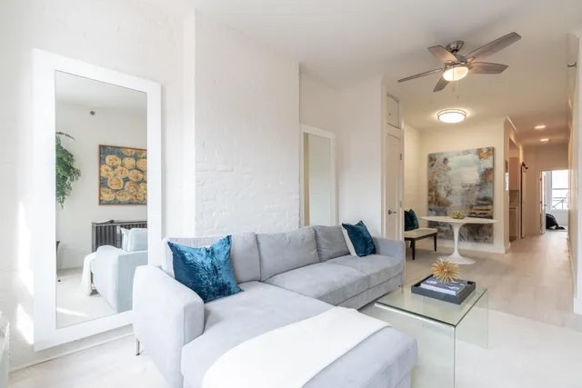 a living room with furniture and a wooden floor