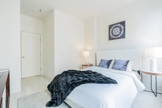 a bedroom with a bed and a painting on the wall