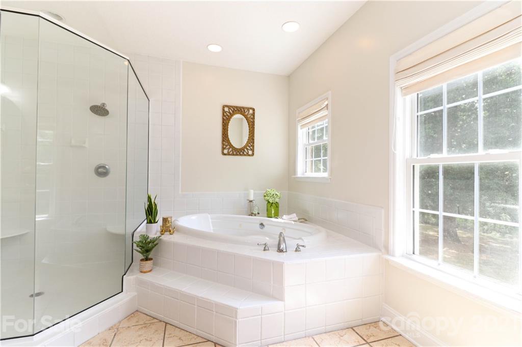 6023 Olive Branch Road Wingate, NC 28174 - Photo 14 of 44 a bathroom with a bathtub and a shower