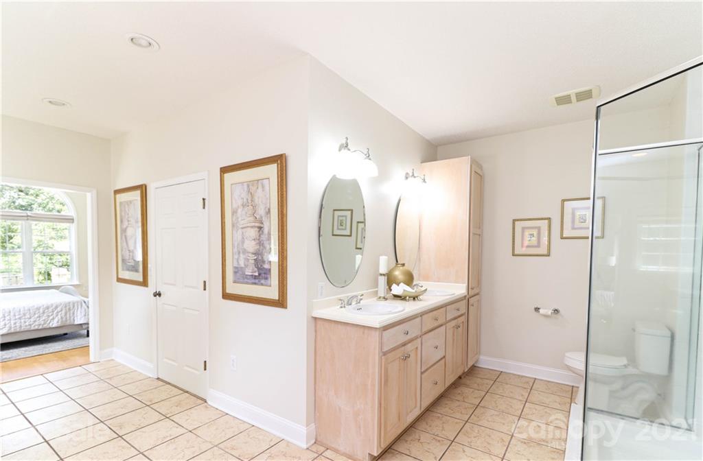 6023 Olive Branch Road Wingate, NC 28174 - Photo 16 of 44 a bathroom with a double vanity sink mirror and bathtub