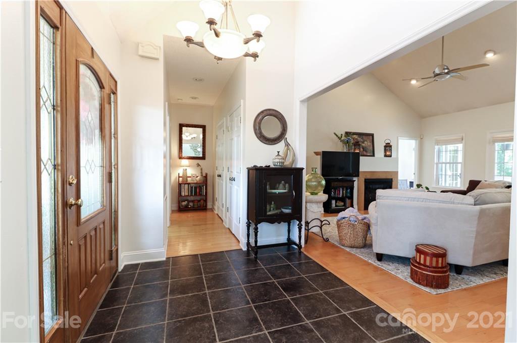 6023 Olive Branch Road Wingate, NC 28174 - Photo 3 of 44 a living room with furniture a fireplace and a chandelier
