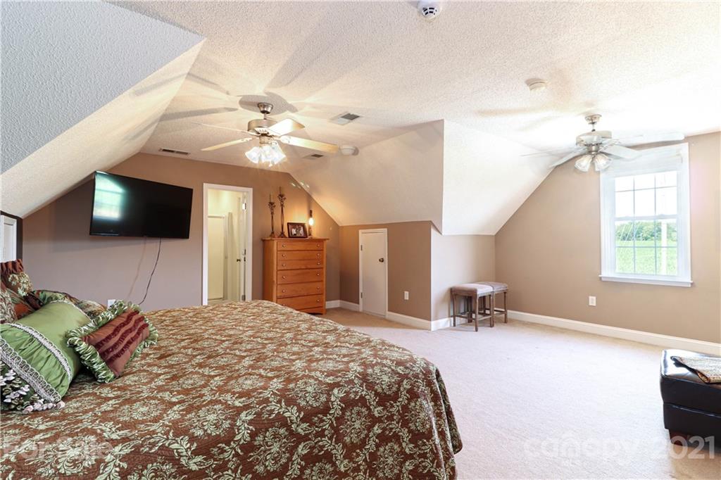 6023 Olive Branch Road Wingate, NC 28174 - Photo 32 of 44 a spacious bedroom with a bed and a flat screen tv